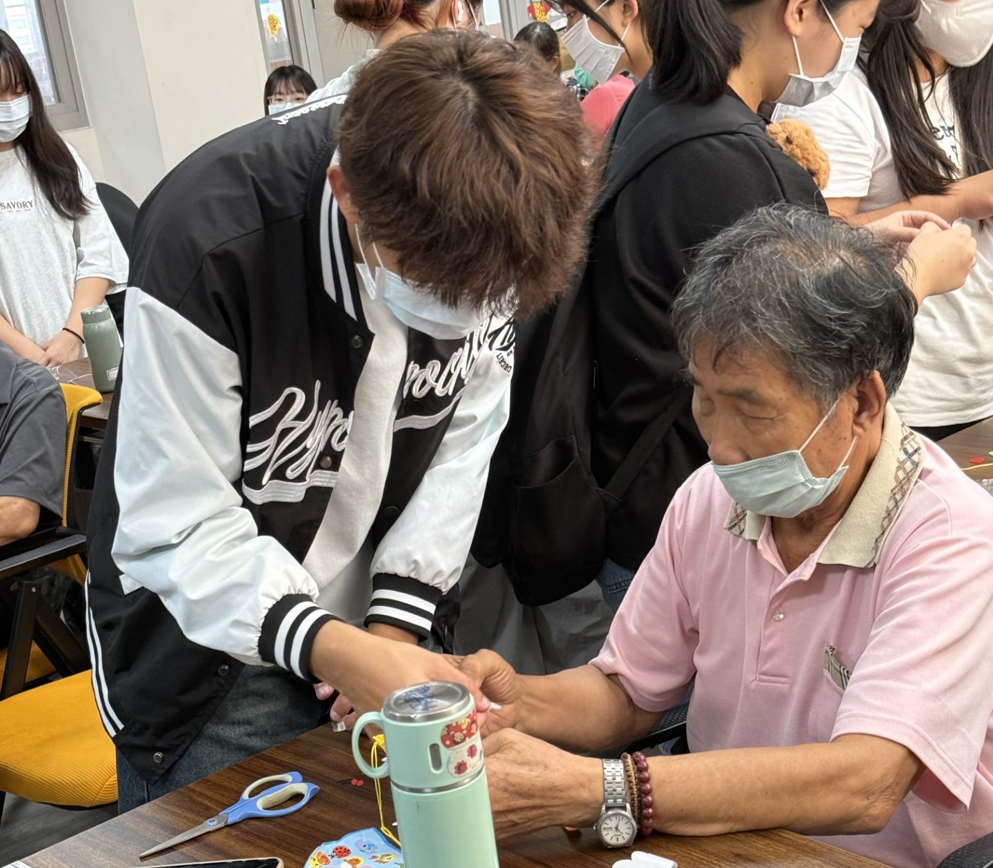 亞大長照系同學，陪伴長輩製作手工吊飾。